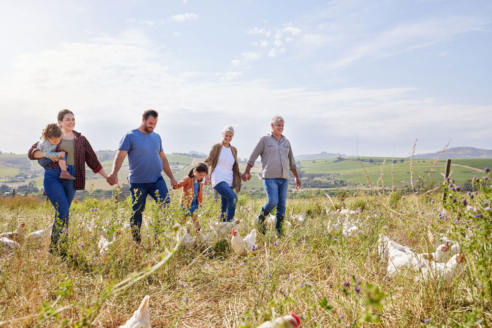 Aufnahme einer Mehrgenerationenfamilie, die auf einem Geflügelhof Zeit miteinander verbringt.