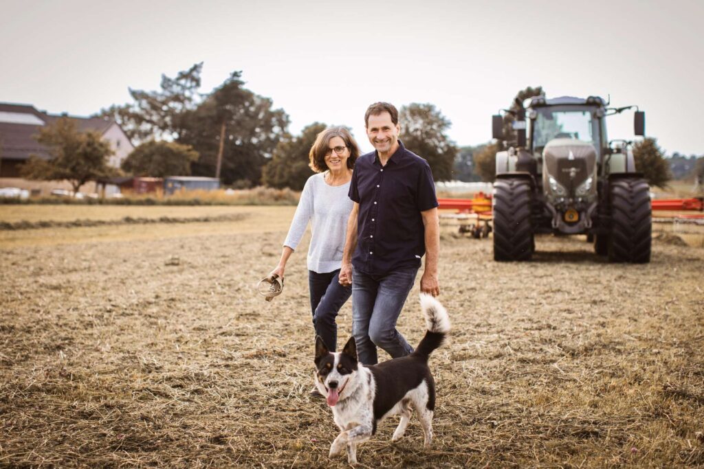 Familie auf einem Bauernhof neben einem Traktor